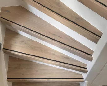 Foto van een trap met houten panelen en antislip rubber